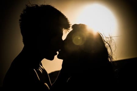 Couple s'embrassant tendrement lors d'un couché de soleil