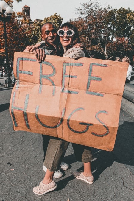Homme et femme tenant une pancarte calins gratuits