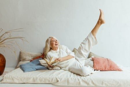 Femme âgée la jambe en l'air dans son lit