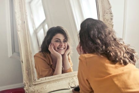 Femme heureuse regardant son reflet dans un miroir