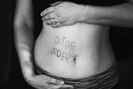 Message Out Of Order | Hors Service écrit sur le ventre d'une femme