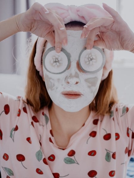 Femme appliquant un masque aux concombres sur son visage