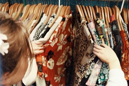 Une femme choisie une robe vintage dans un magasin