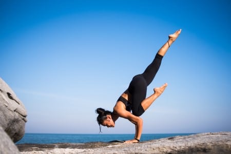 Jeune femme pratiquant une figure de yoga acrobatique